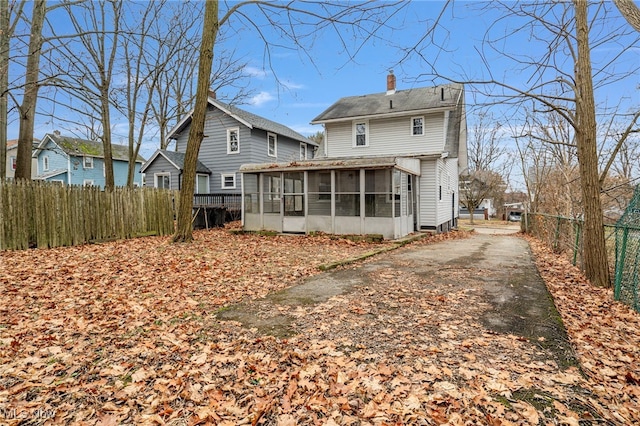 rear view of property featuring a sunroom