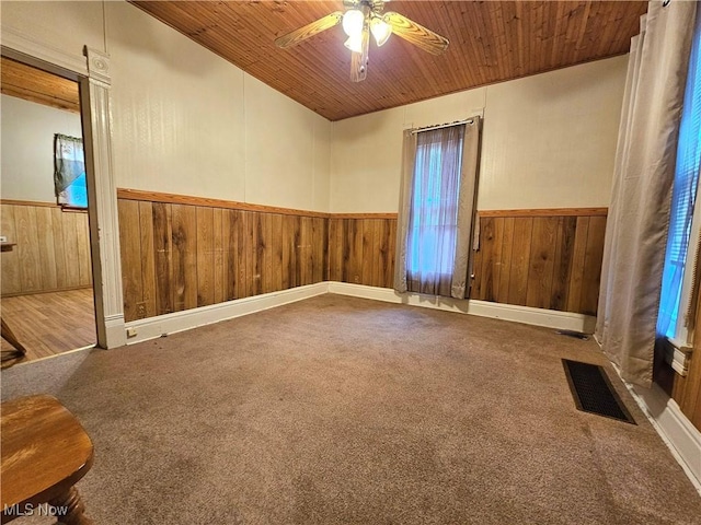 carpeted empty room with ceiling fan and wooden ceiling