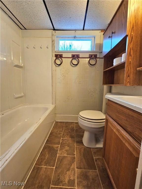 full bathroom featuring vanity, a paneled ceiling, bathing tub / shower combination, and toilet