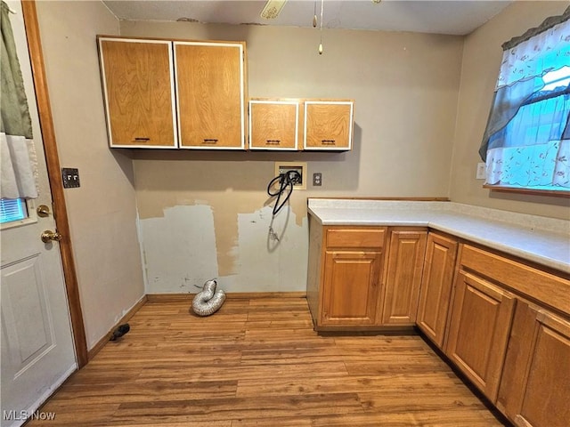 washroom featuring washer hookup, cabinets, and light hardwood / wood-style floors