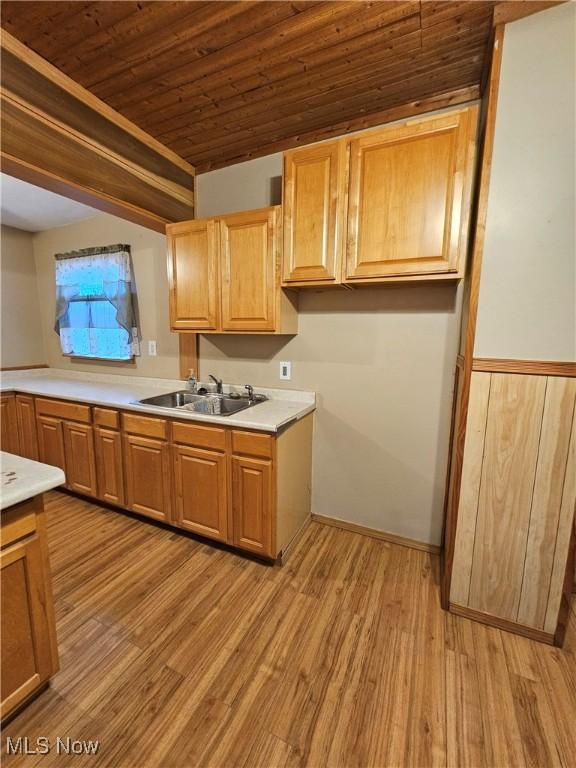 kitchen with sink, wood ceiling, and light hardwood / wood-style flooring