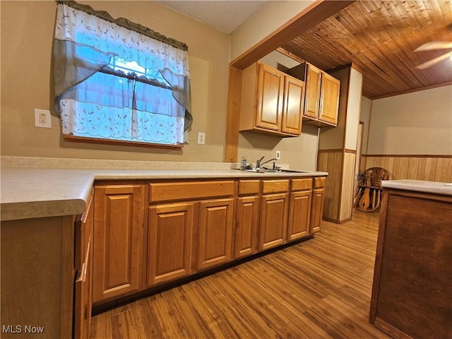 kitchen featuring wood walls, wooden ceiling, sink, light hardwood / wood-style flooring, and ceiling fan