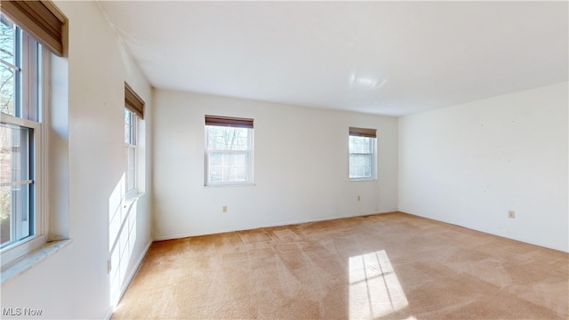 carpeted spare room featuring plenty of natural light