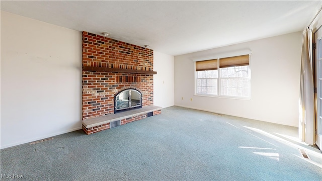 unfurnished living room featuring carpet floors and a brick fireplace