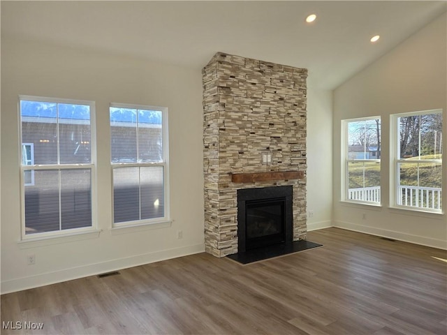 unfurnished living room featuring a fireplace, wood-type flooring, and vaulted ceiling