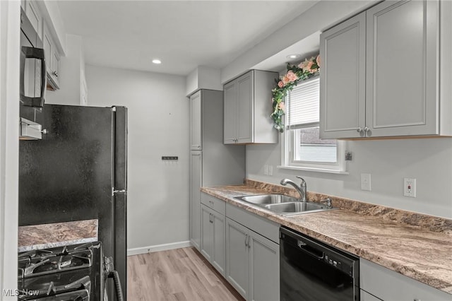 kitchen featuring sink, gray cabinets, light hardwood / wood-style flooring, and black appliances