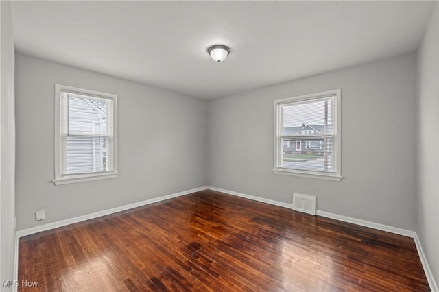 empty room with dark hardwood / wood-style flooring