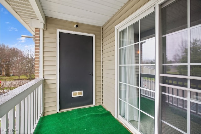 view of exterior entry featuring a balcony