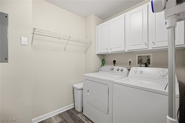 washroom with dark hardwood / wood-style floors, cabinets, and washing machine and dryer