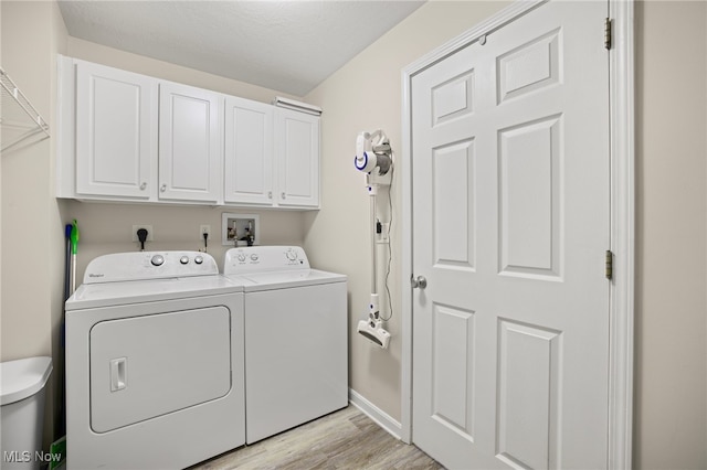 laundry room with washer and dryer, cabinets, and light hardwood / wood-style flooring