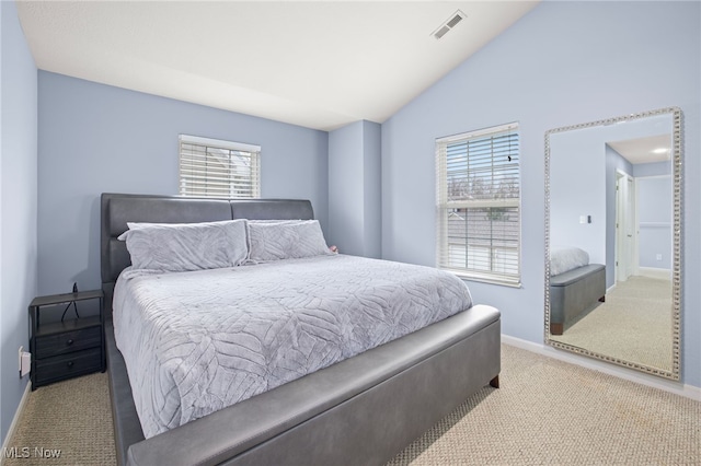 bedroom featuring multiple windows, light carpet, and lofted ceiling