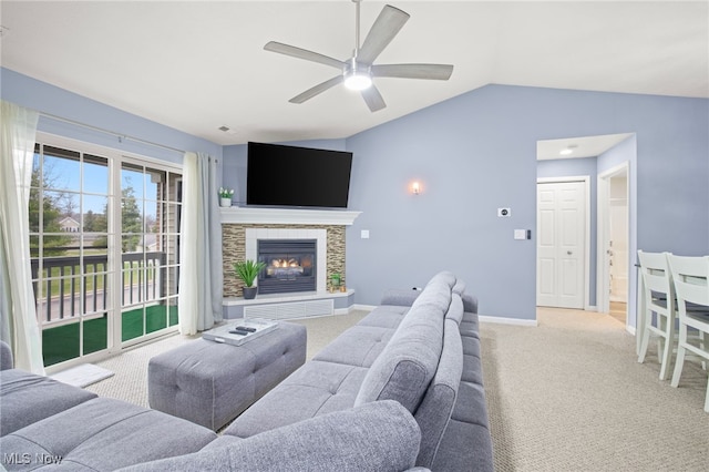 living room with light carpet, a stone fireplace, ceiling fan, and lofted ceiling