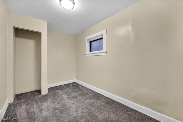 spare room with dark colored carpet