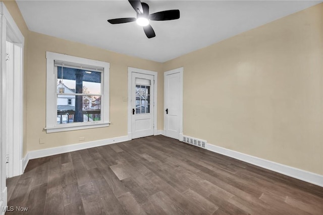 empty room with ceiling fan and dark hardwood / wood-style floors