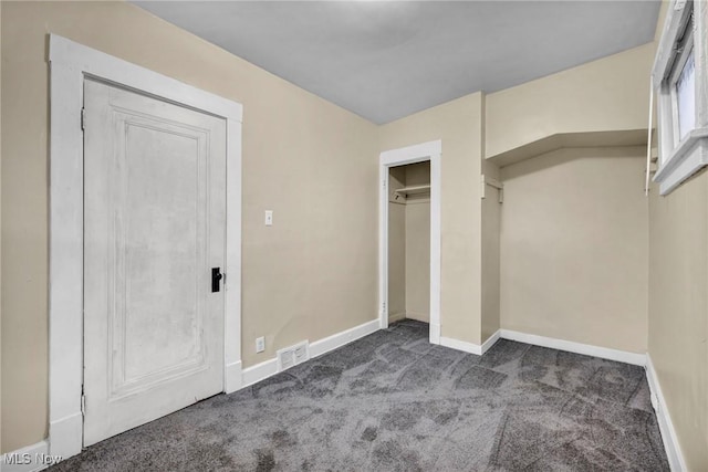 unfurnished bedroom with a closet and dark carpet