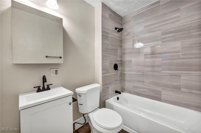 full bathroom with a textured ceiling, vanity, toilet, and tiled shower / bath