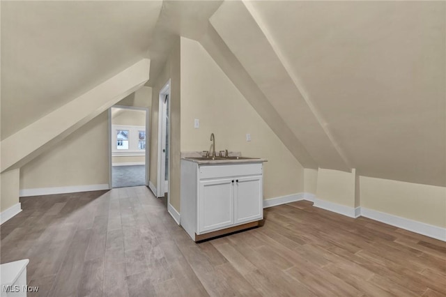 bonus room featuring light hardwood / wood-style floors, lofted ceiling, and sink