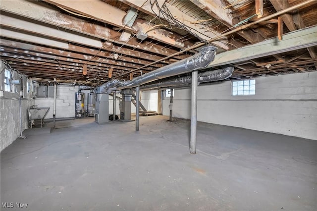 basement featuring gas water heater, heating unit, and water heater