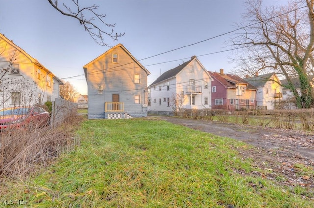 rear view of property featuring a lawn