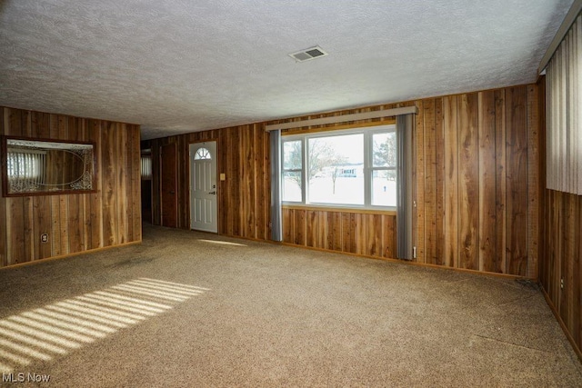 carpeted spare room featuring a textured ceiling