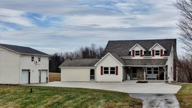 cape cod-style house featuring a garage, covered porch, and a front lawn