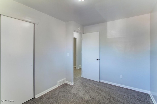 unfurnished bedroom featuring carpet and a closet