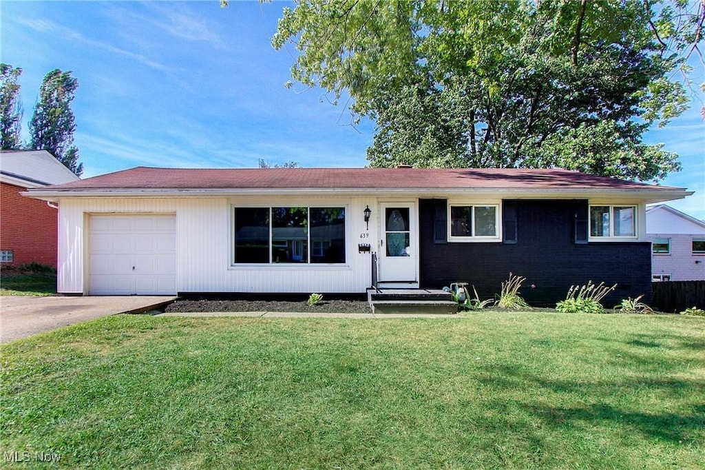 single story home featuring a front lawn and a garage