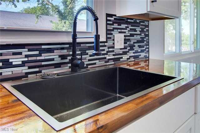 details with tasteful backsplash, butcher block counters, and sink