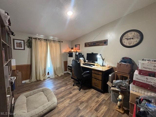 office featuring a textured ceiling, hardwood / wood-style flooring, and lofted ceiling