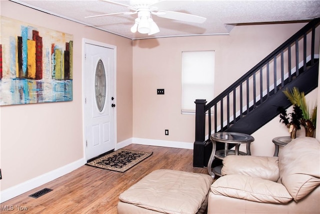 foyer entrance with a textured ceiling, hardwood / wood-style flooring, and ceiling fan