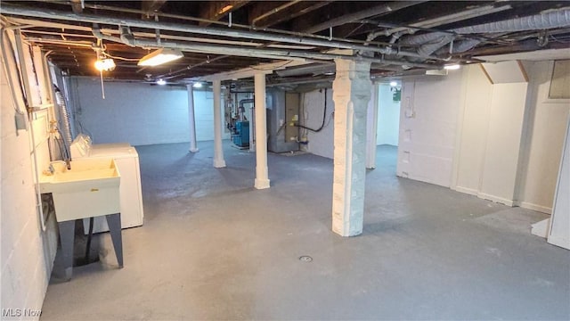 basement with washer and dryer, heating unit, and sink