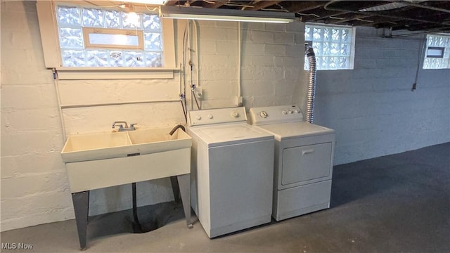 clothes washing area with washing machine and clothes dryer and sink