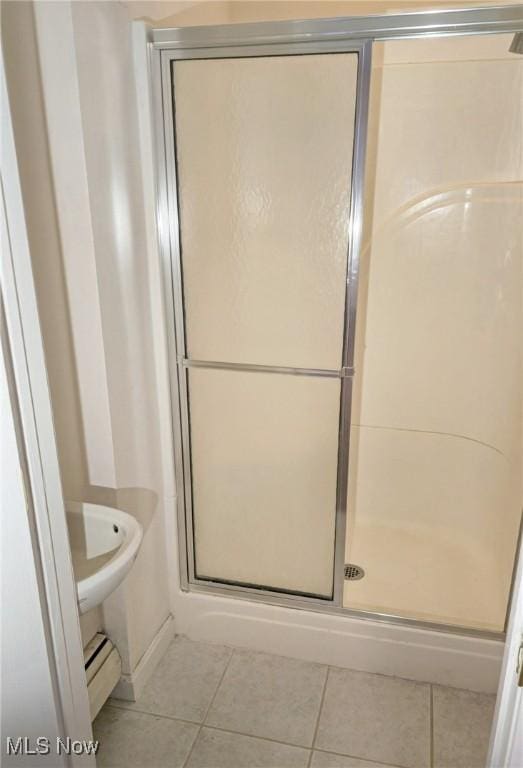 bathroom with tile patterned flooring, walk in shower, and a baseboard radiator