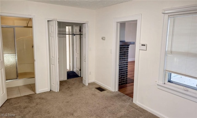 unfurnished bedroom featuring carpet, a textured ceiling, and connected bathroom