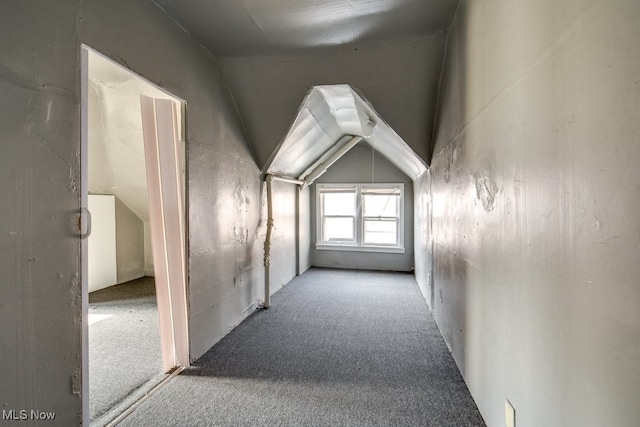 hall featuring carpet flooring and lofted ceiling