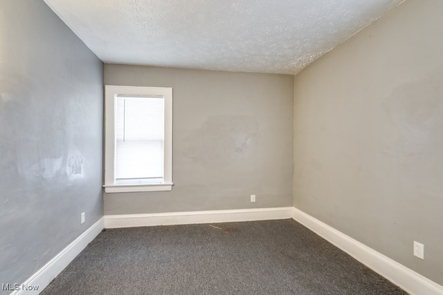 carpeted empty room featuring a textured ceiling