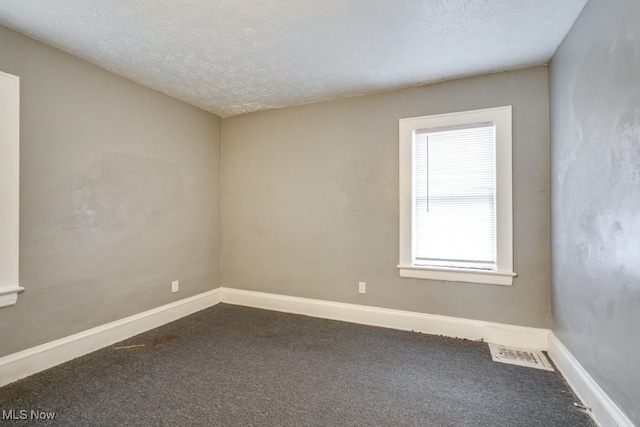 unfurnished room featuring a textured ceiling and carpet floors