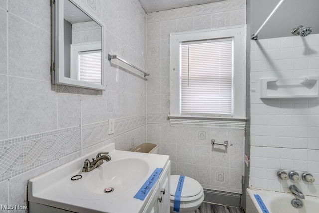 bathroom with vanity, toilet, and tile walls