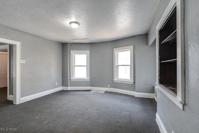 carpeted spare room featuring a textured ceiling