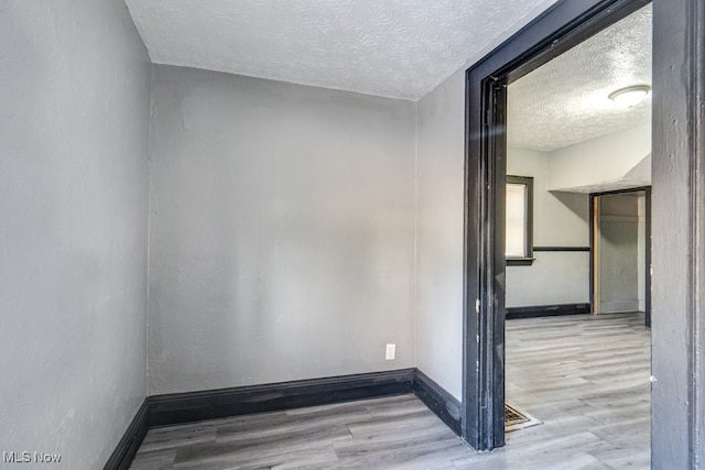 empty room featuring light hardwood / wood-style floors and a textured ceiling