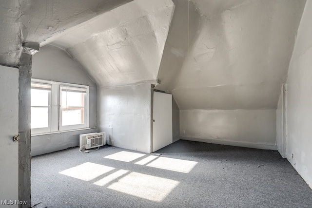 bonus room with vaulted ceiling, light colored carpet, and a wall unit AC