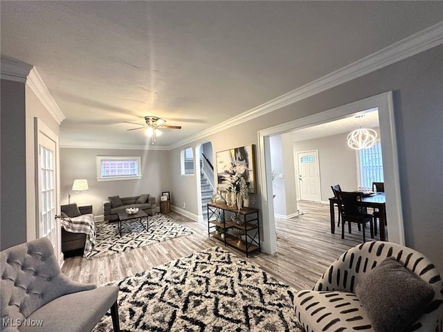 living room with crown molding, ceiling fan, and light hardwood / wood-style floors