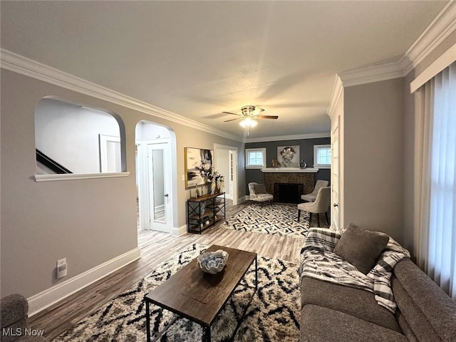 living room featuring hardwood / wood-style floors, ceiling fan, and crown molding