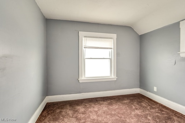 unfurnished room with carpet flooring and vaulted ceiling