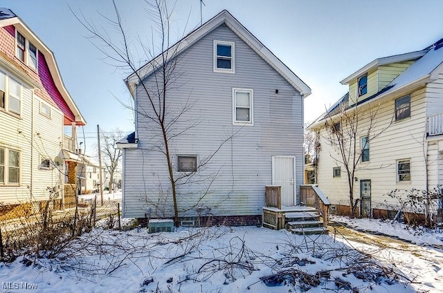 view of snow covered rear of property