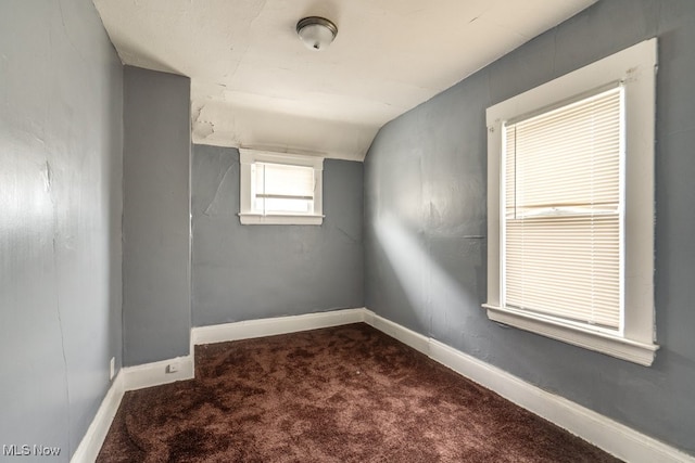 unfurnished room featuring carpet flooring and lofted ceiling