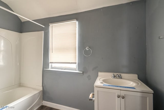 bathroom with hardwood / wood-style flooring, vanity, and tub / shower combination