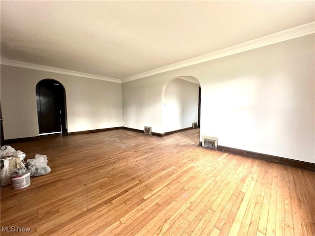 empty room with hardwood / wood-style floors and ornamental molding