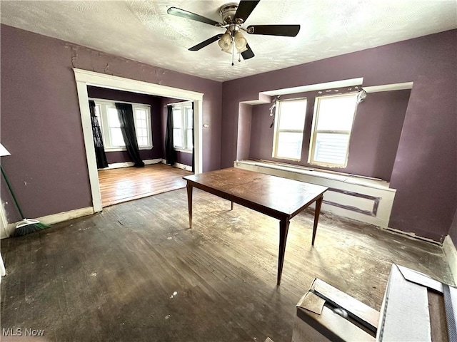 misc room with ceiling fan, dark hardwood / wood-style flooring, and a textured ceiling