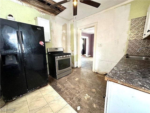 kitchen with black fridge, sink, stainless steel gas range, ceiling fan, and white cabinetry